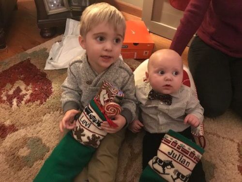 Two little boys with traditional knit christmas stockings