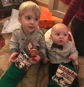 Two little boys with traditional knit christmas stockings